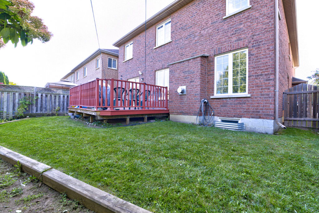 Backyard deck with green lawn from elevated viewpoint