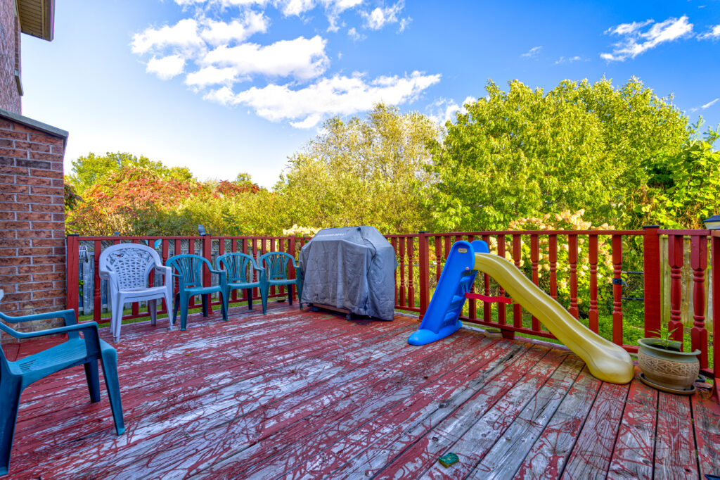 Backyard deck with wooden railing at sunset